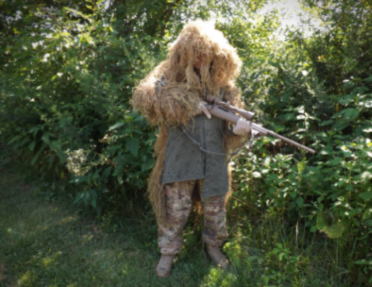 Trained sniper in ghillie suit - stress shooting.