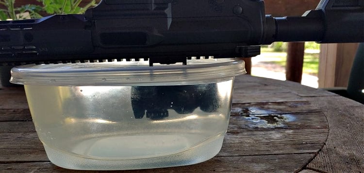 Sig Romeo-MSR submerged in water in tupperware container for waterproof testing.