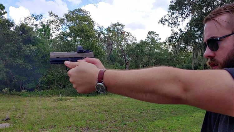 Travis Pike aiming a P320 with an Amend2 s300 grip module and Sig ROMEOPRO red dot sight