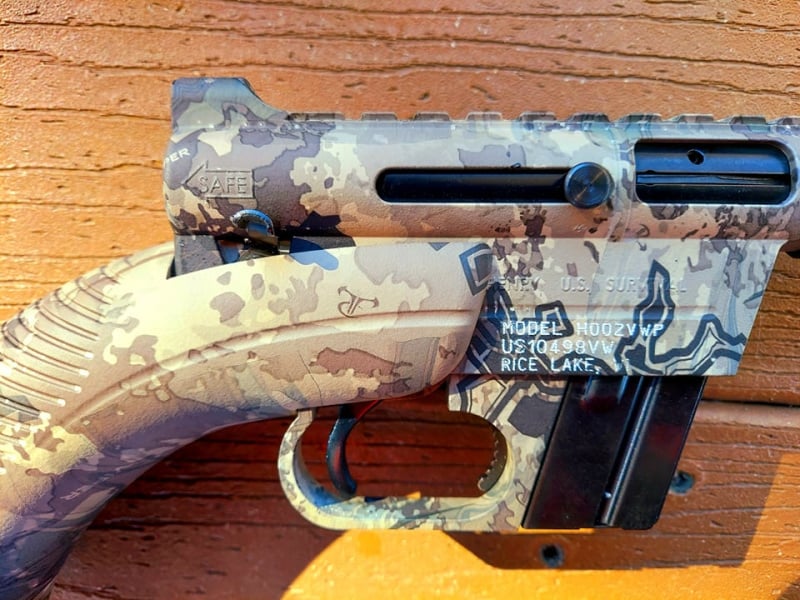 Side view of Henry AR-7 receiver showing the safety lever, trigger, charging handle, and magazine release