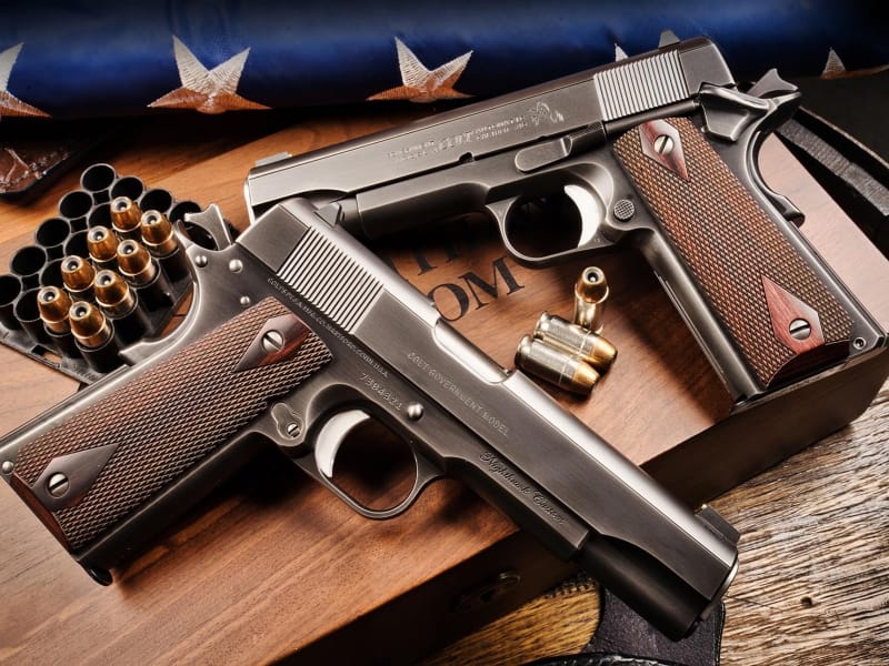 1911 series 70 nighthawks laying with flag and bullets
