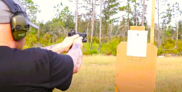 Aaron Cowan aiming handgun at Eleanor Drill target
