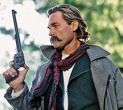 Kurt Russell as Wyatt Earp holding one the guns of Tombstone