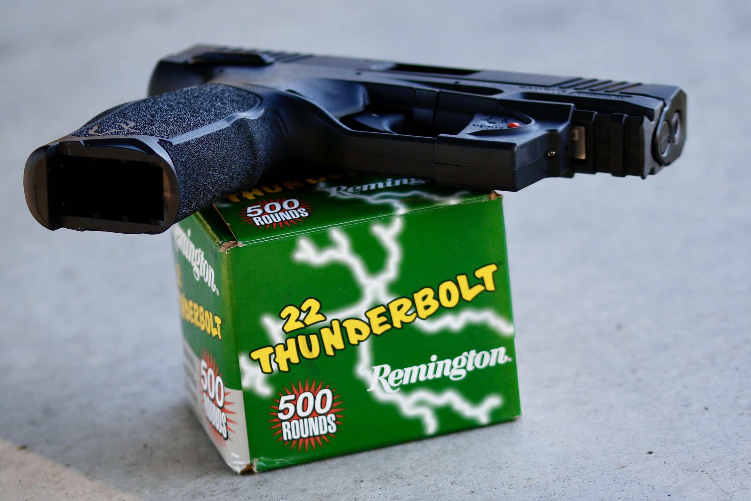Taurus TX22 mid-sized rimfire pistol on top of a box of Remington 22 Thunderbolt cartridges