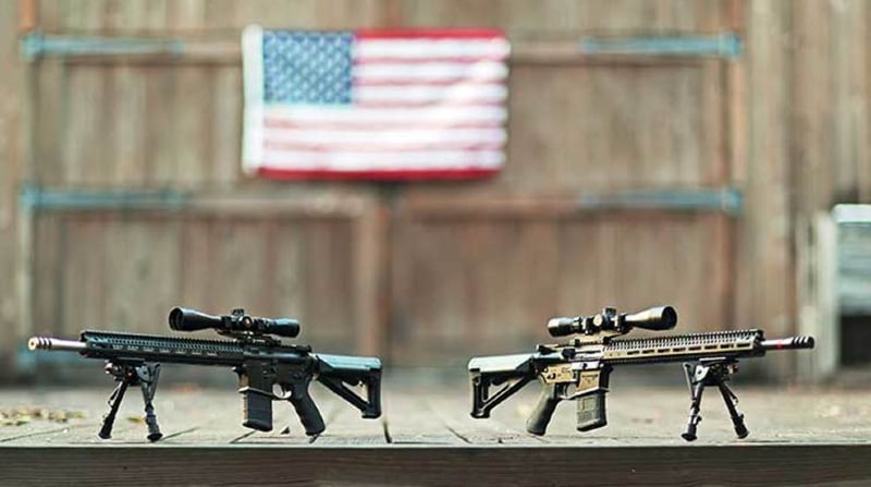 AR-15's on a deck with an American flag in the background.