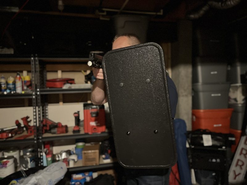 mini shield held up to guard against home intruder