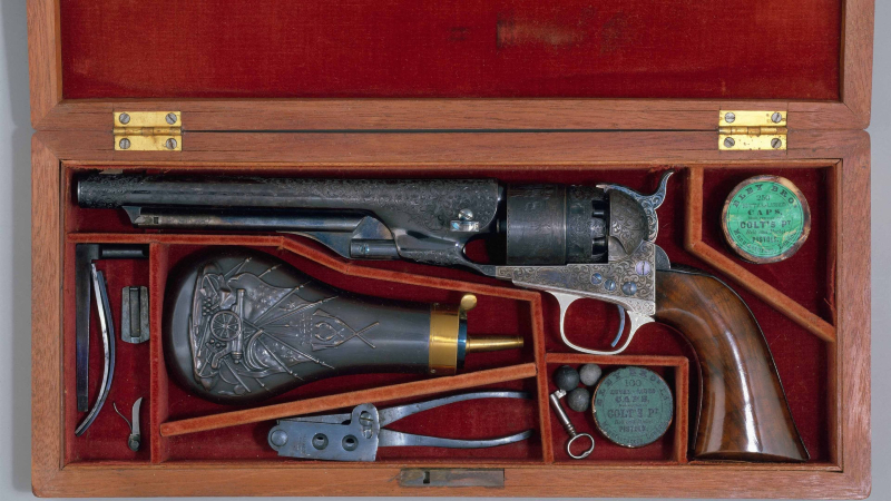 An original Colt revolver, shown with all the accessories it was sold with.