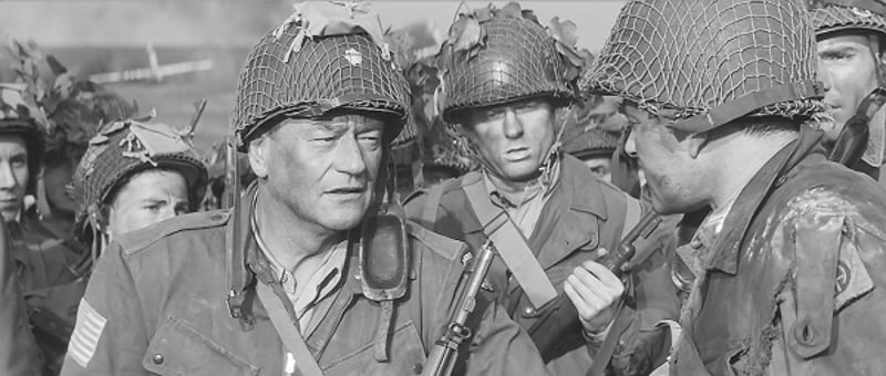 John Wayne as Lt. Col. Benjamin Vandervoort of the 82nd Airborne with an M1 Rifle he's using as a crutch.