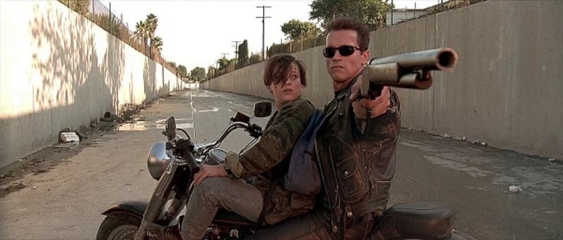 Arnold takes aim with his sawed-off Winchester 1887 shotgun.