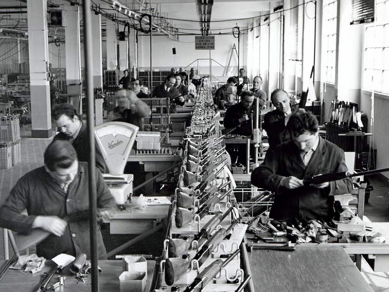 black and white historical image of workers inside the Beretta Factory