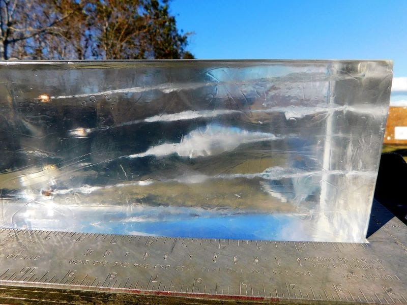 A gelatin block perforated with 25 ACP projectiles. A square is placed for reference.