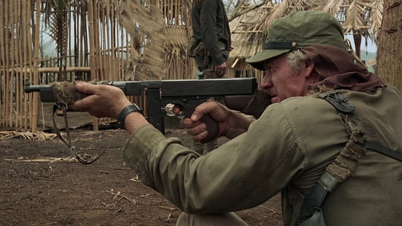 Tim Thomerson is seen holding a Thompson SMG
