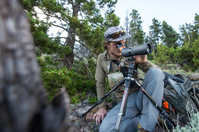 hunter sitting on spotting scope