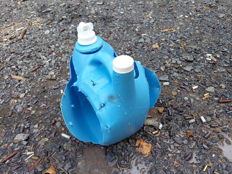 A formerly water-filled jug that was hit by buckshot.