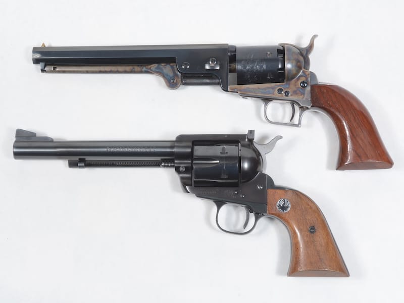This photo shows a Second Generation Colt 1851 cap and ball revolver with the Flattop Blackhawk to show how both have the same grip, but the 1851 has an unusual triggerguard that appeared on some later Rugers.