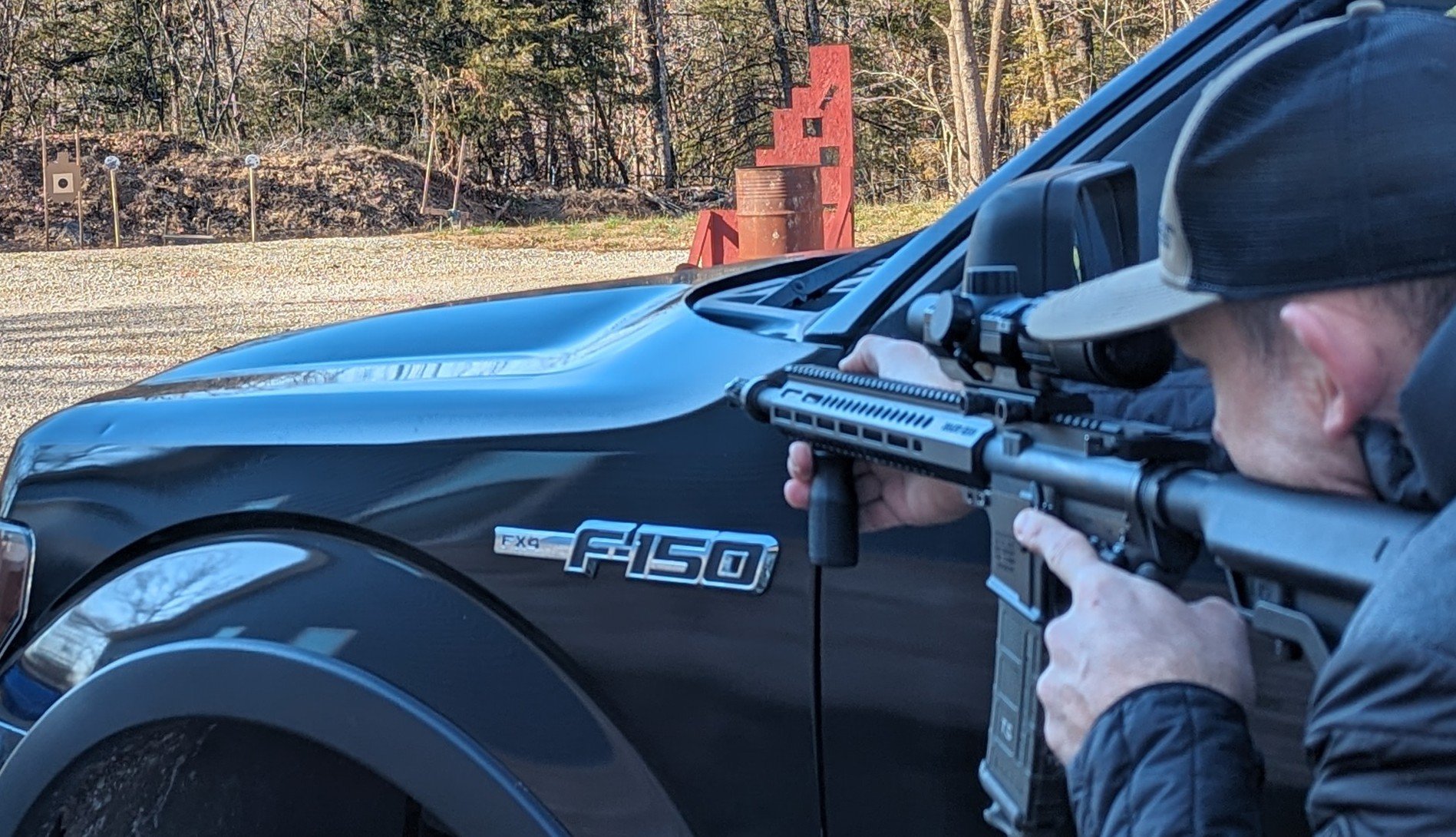 scope over bore offset with rifle next to truck