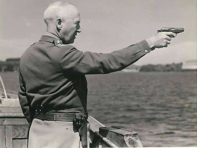 General George S. Patton, Jr. firing a pistol