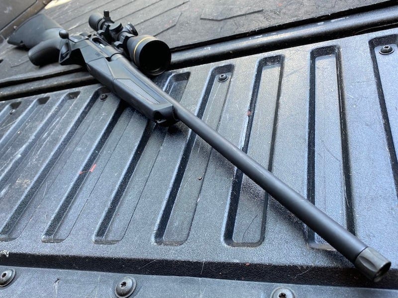The muzzle is protected by a cap and threaded to accept a suppressor.