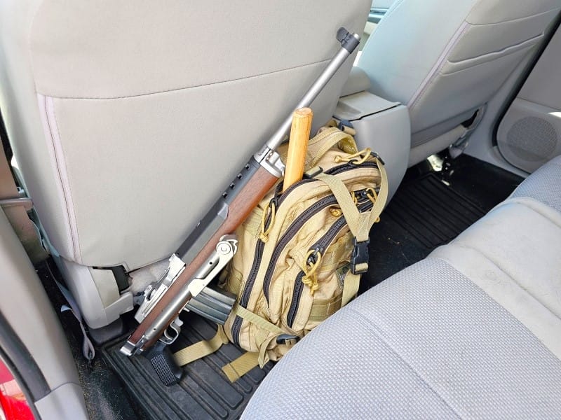 Mini-14 stowed behind a car seat.